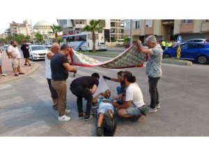 Kazada yaralanan motosiklet sürücüsünü çarşafla güneşten korumaya çalıştılar