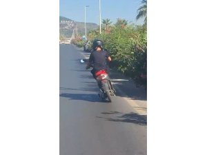 ALANYA’DA MOTOSİKLET ÜZERİNDE AYAKTA İLERLEYEN SÜRÜCÜNÜN TEHLİKELİ YOLCULUĞU KAMERADA