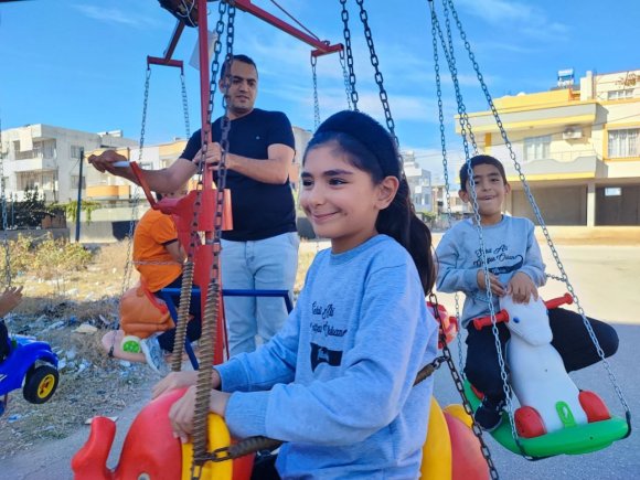 KENDİ ÇOCUKKEN HİÇ BİNMEDİ: MAHALLE MAHALLE GEZEREK ÇOCUKLARI DÖNME DOLABINA BİNDİRİYOR