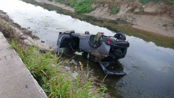 KAYGANLAŞAN YOLDA KONTROLDEN ÇIKAN ARAÇ KANALA UÇTU