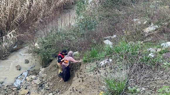 DERE YATAĞINA DÜŞEN OĞLAĞI KURTARMAK İSTEYEN KADIN MAHSUR KALDI