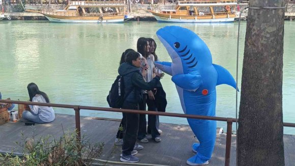 VATANDAŞLARI EĞLENDİRMEK İÇİN KÖPEK BALIĞI KOSTÜMÜYLE MANAVGAT SOKAKLARINDA DOLAŞIYOR