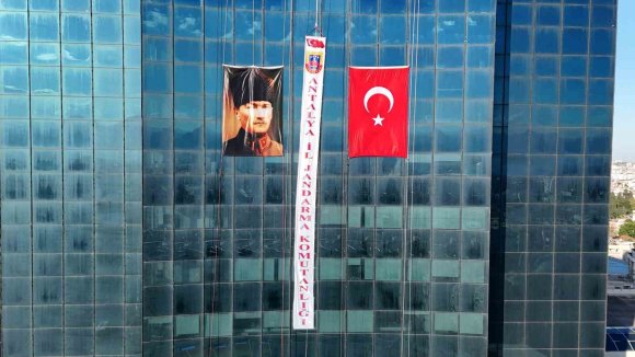 ANTALYA’DA JAK TİMİ, HALATLA SARKTIKLARI 64 METRE YÜKSEKLİKTE TÜRK BAYRAĞI AÇTI