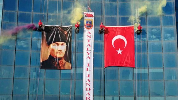 ANTALYA’DA JAK TİMİ, HALATLA SARKTIKLARI 64 METRE YÜKSEKLİKTE TÜRK BAYRAĞI AÇTI