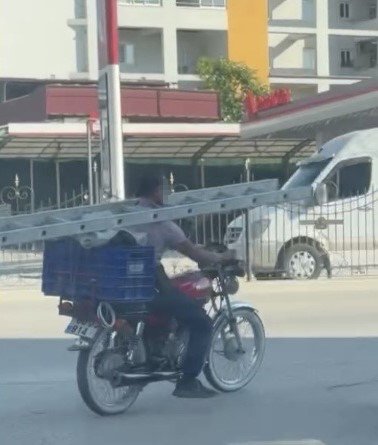 BOYNUNDA MERDİVENLE MOTOSİKLET KULLANDI